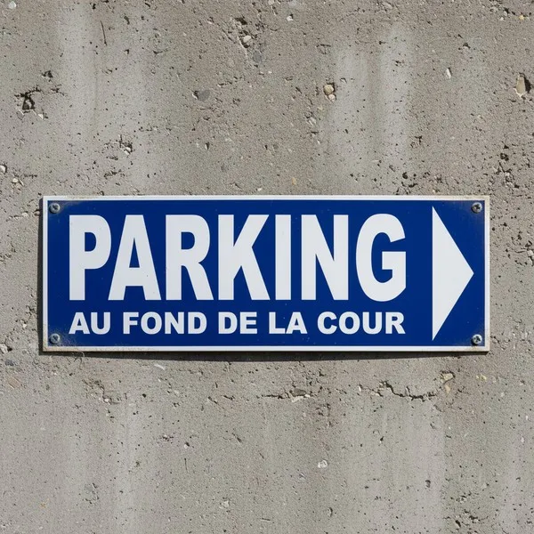 Panneau Parking : direction droite au fond de la cour