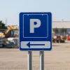 Panneau parking avec flèche à gauche, fond bleu