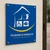 Panneau bleu Label Tourisme et Handicap avec pictogrammes, fixé sur un mur clair