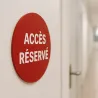 Panneau personnalisé rond en PVC rigide rouge, vissé sur une porte de clinique
