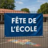 Banderole personnalisée en bâche PVC, tendue par ses œillets sur la clôture d'une école
