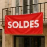 Banderole personnalisée suspendue au balcon d'une façade de commerce