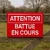 Panneau Attention battue en cours vissé sur une barrière en bois