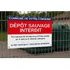 Panneau Dépôt sauvage interdit au nom de la commune sur le grillage d'un point de collecte